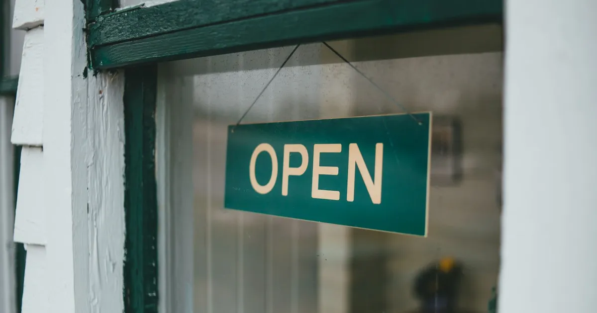 Green 'OPEN' sign in a restaurant shop window